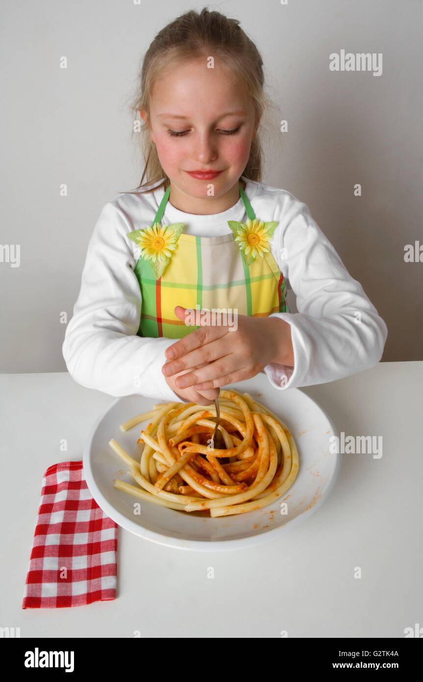 Girl twisting macaroni with tomato sauce around her fork Stock Photo Alamy