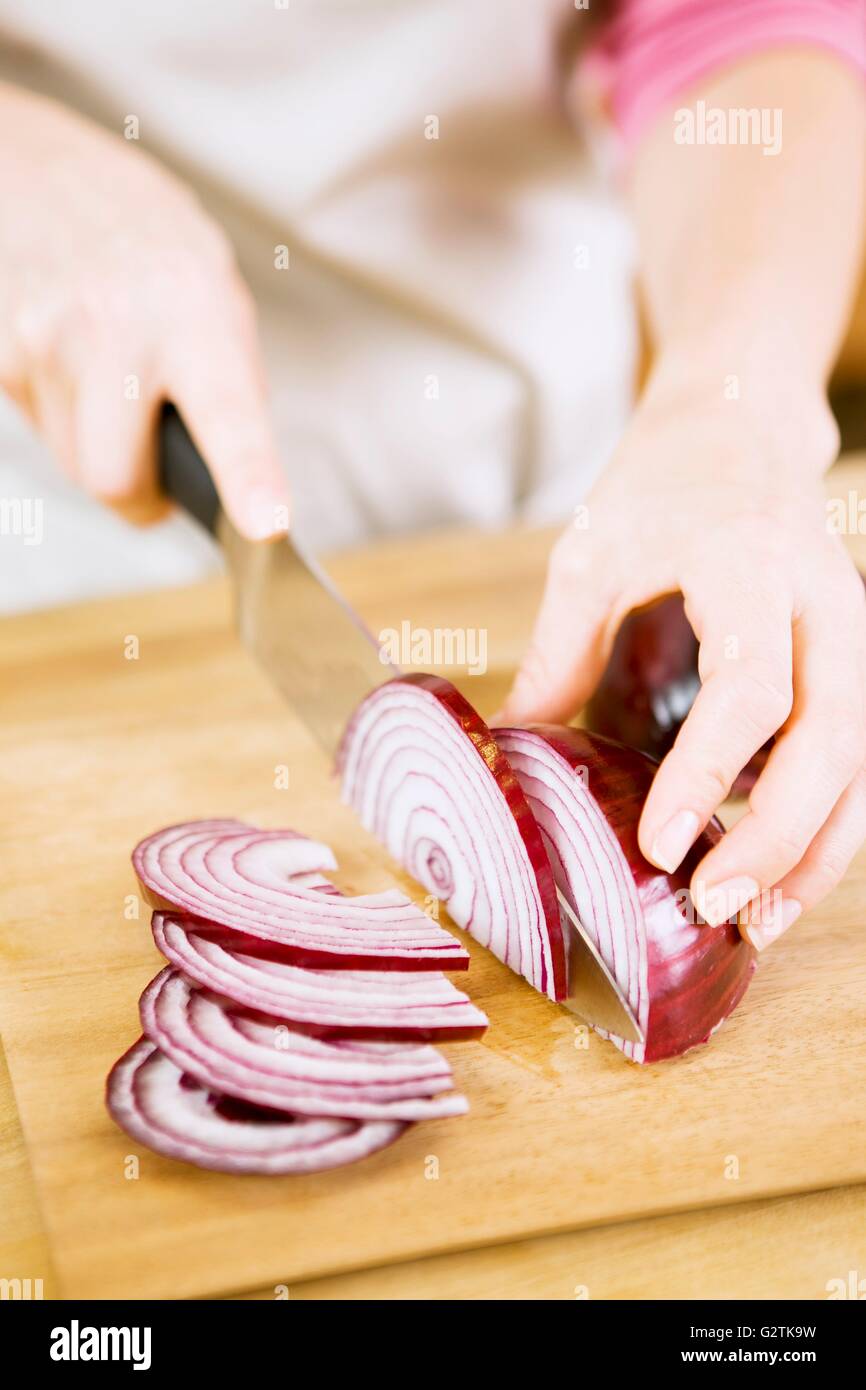 Woman Slicing Red Onion on Cutting Board Stock Photo - Alamy