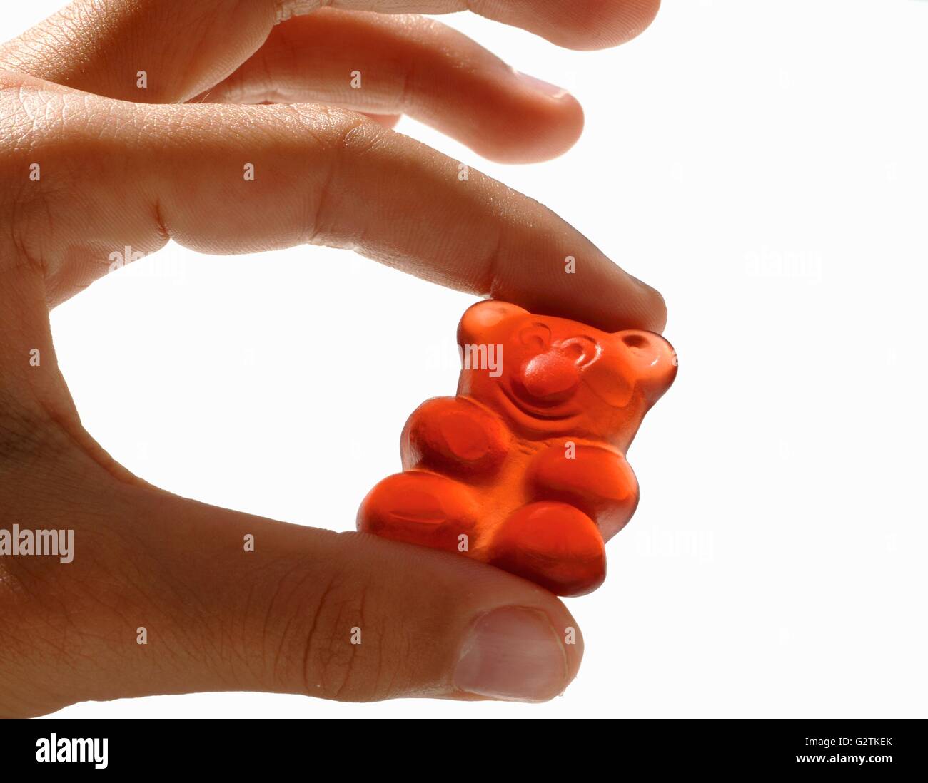 Hand holding a gummi bear Stock Photo Alamy