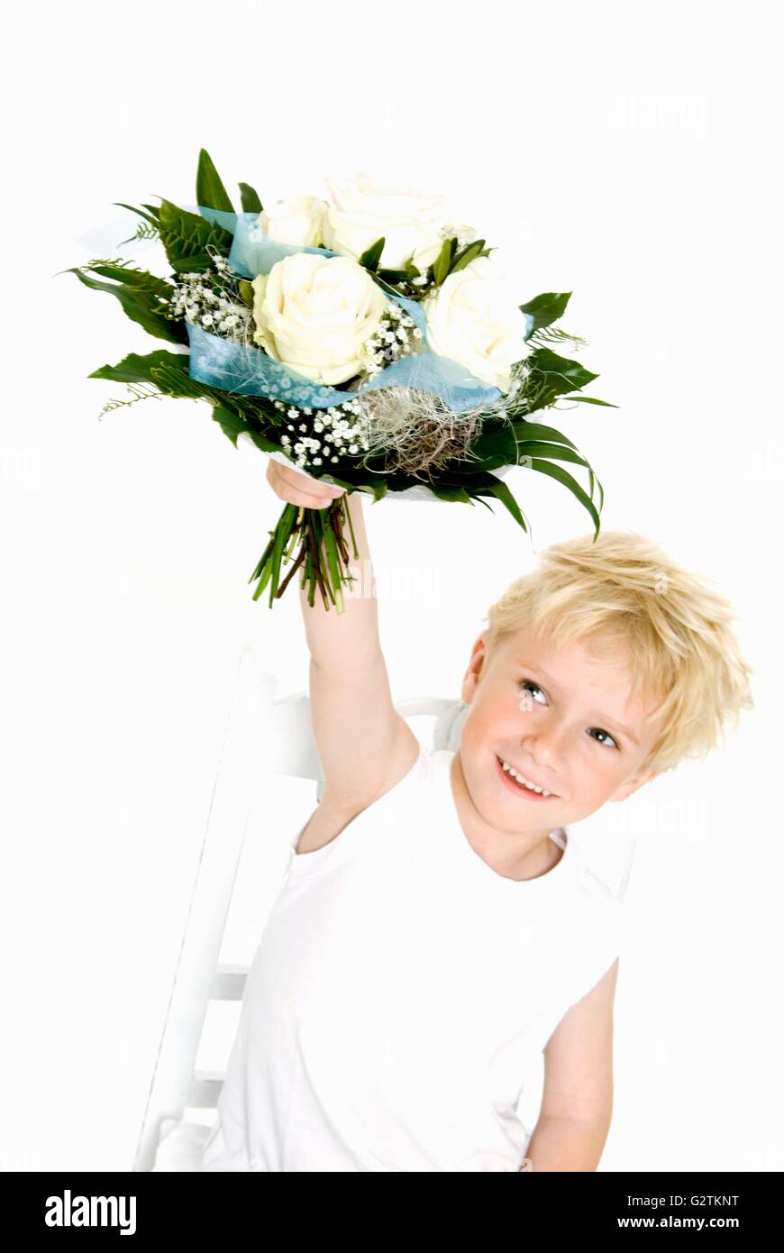 Blond boy holding bouquet of white roses Stock Photo
