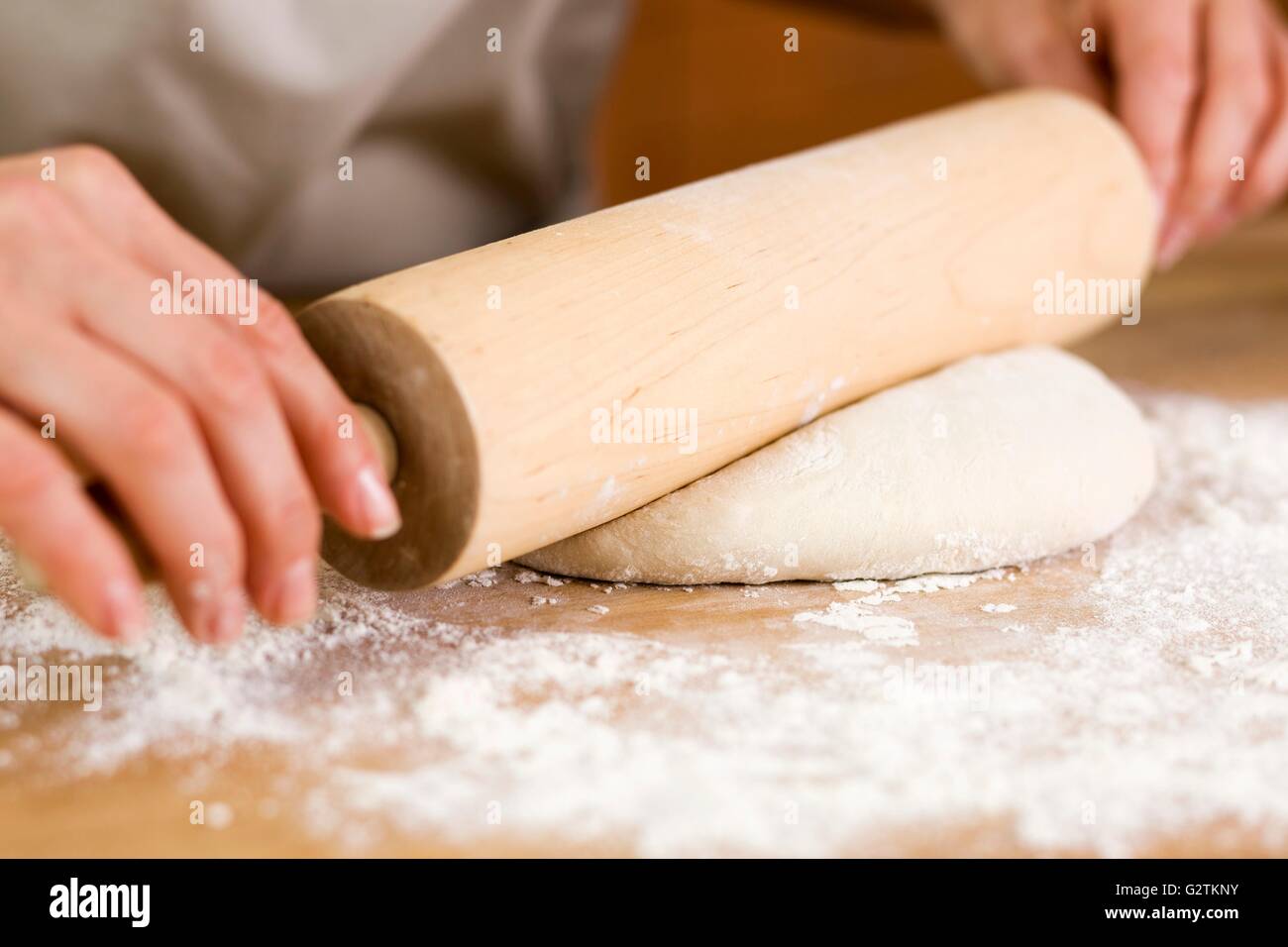 Woman Rolling Out Dough with a Rolling Pin Stock Photo