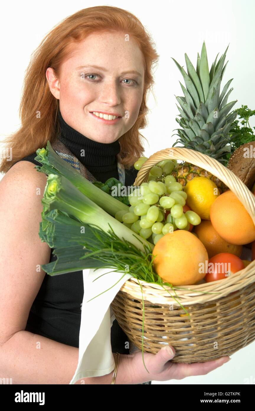 Young woman holding a basket of fruit and vegetables Stock Photo - Alamy