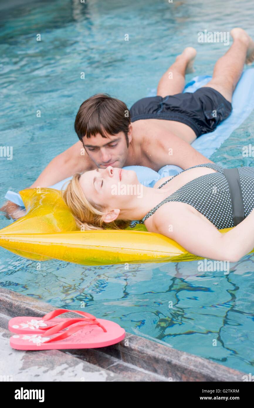 Man and woman on air beds in water Stock Photo