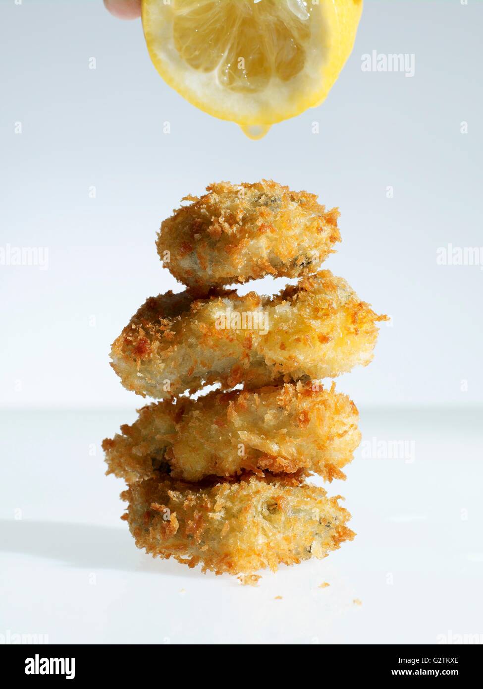 Breaded oysters being drizzled with lemon juice Stock Photo Alamy