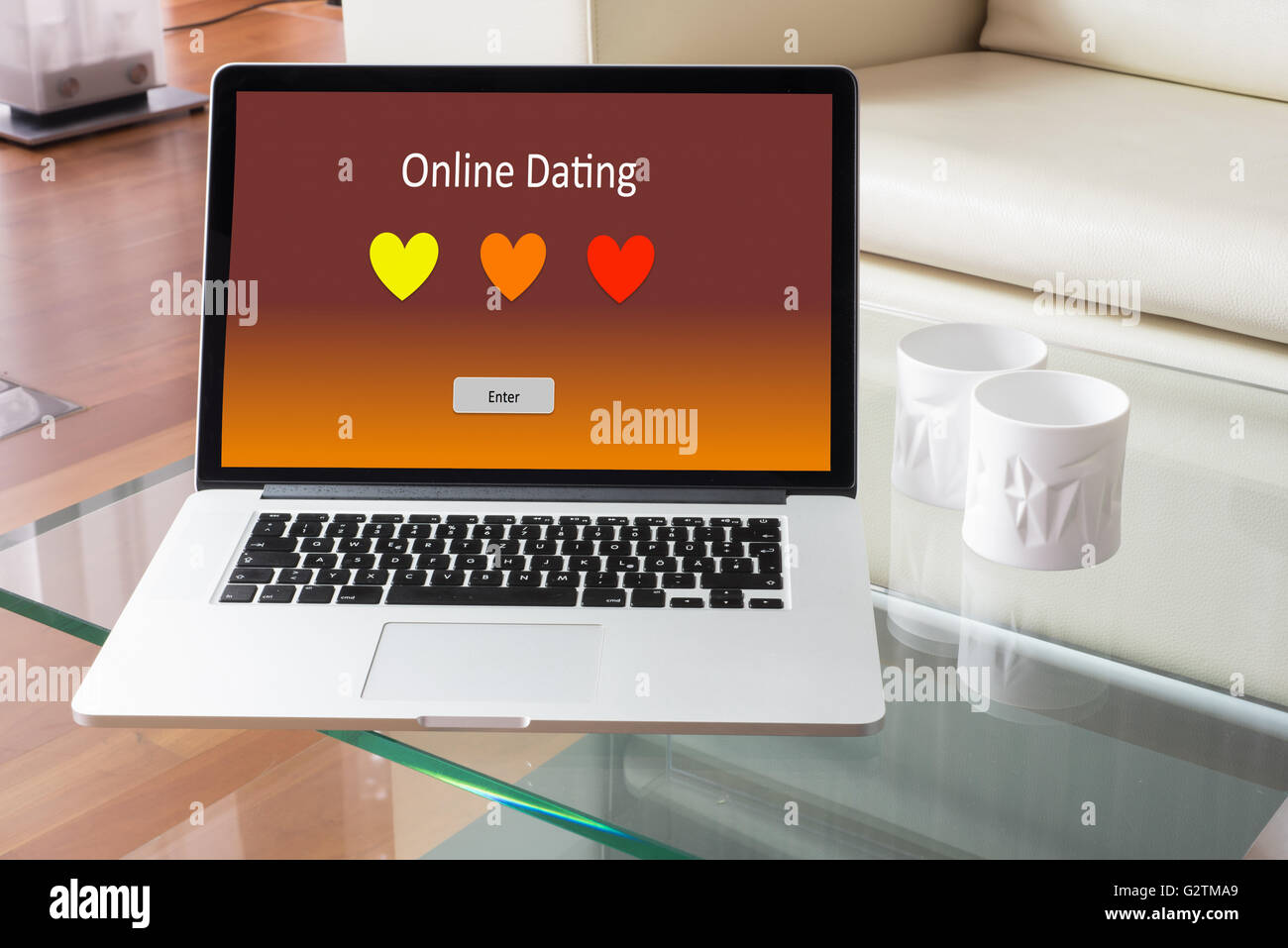 Laptop standing on glass table - with Online Dating Stock Photo