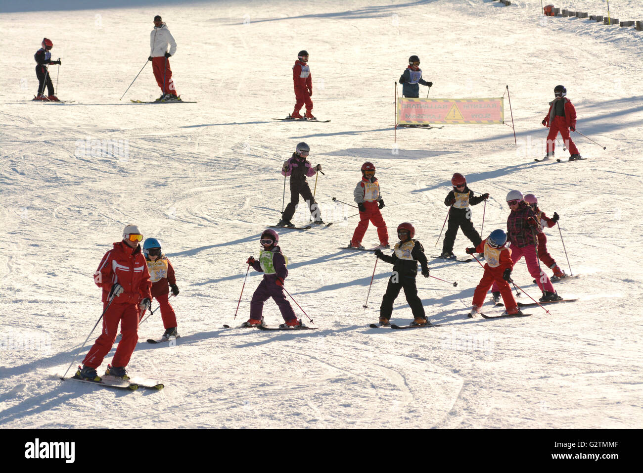 Children learning to ski at a ski school at a ski resort, Le Mont Dore, Puy de Dôme, Auvergne, France Stock Photo