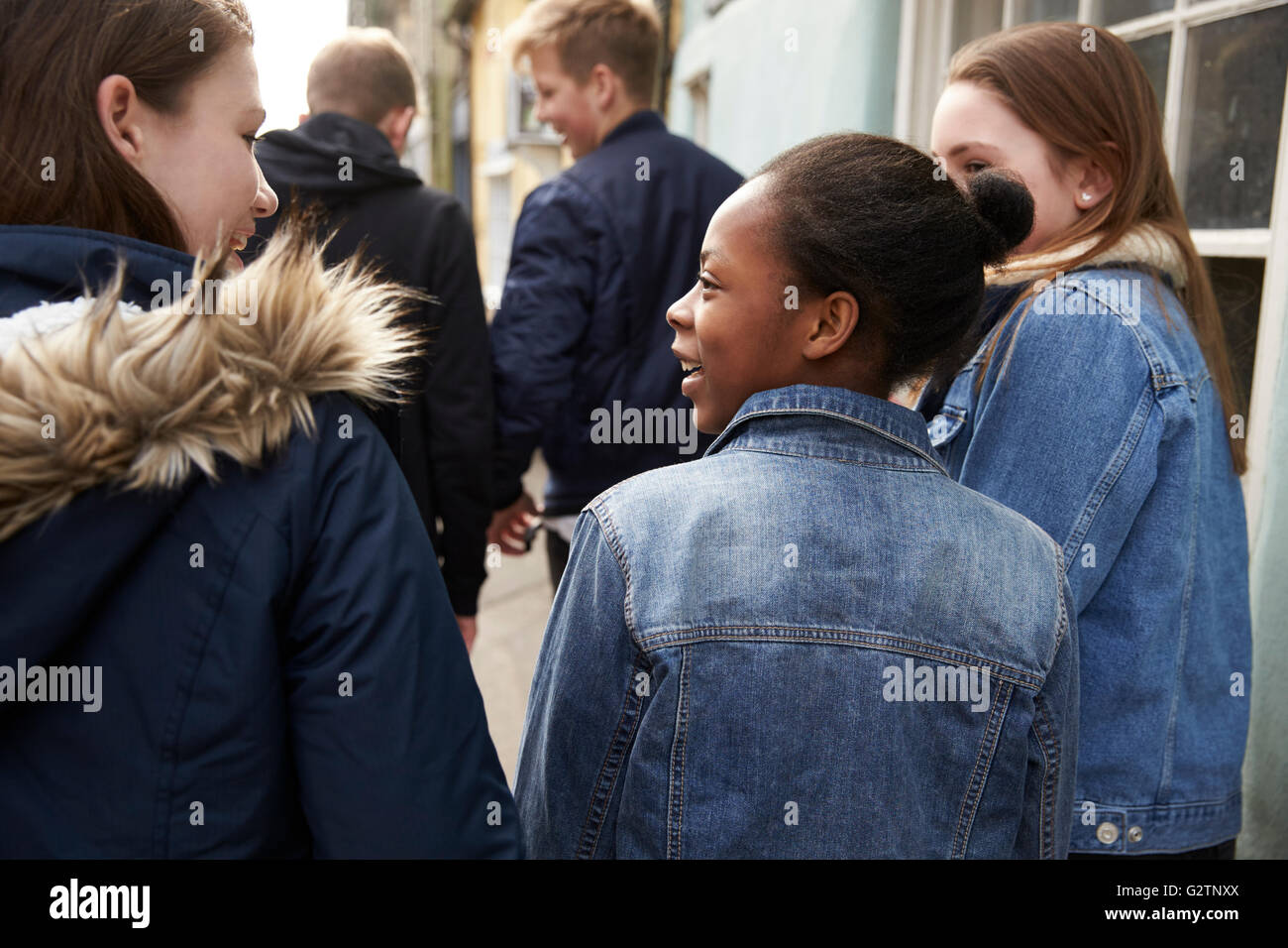Rear View Of Teenagers Walking Along Urban Street Stock Photo - Alamy