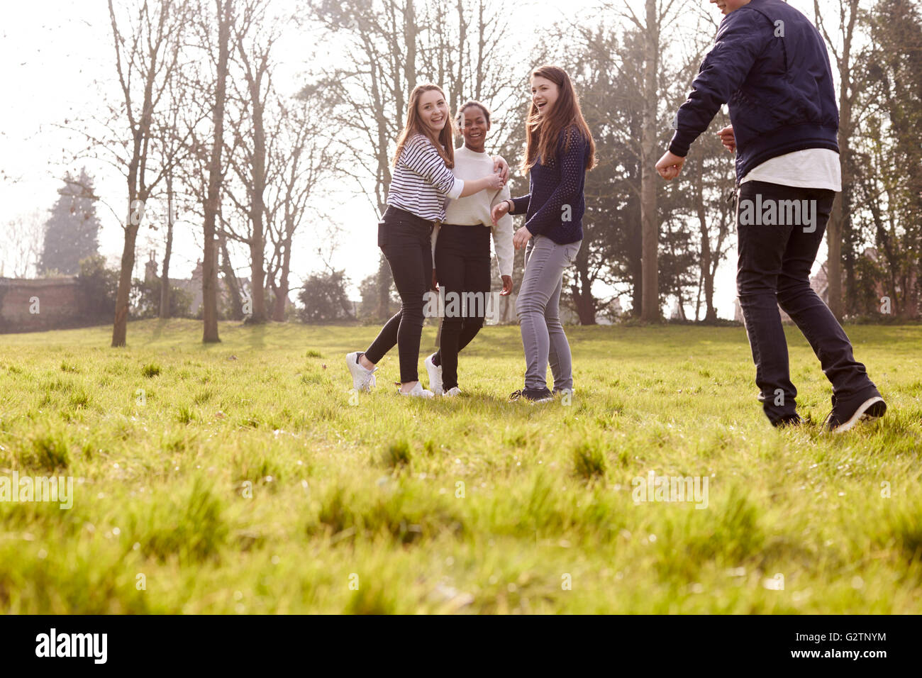 Group Of Teenagers Playing Soccer In Park Together Stock Photo