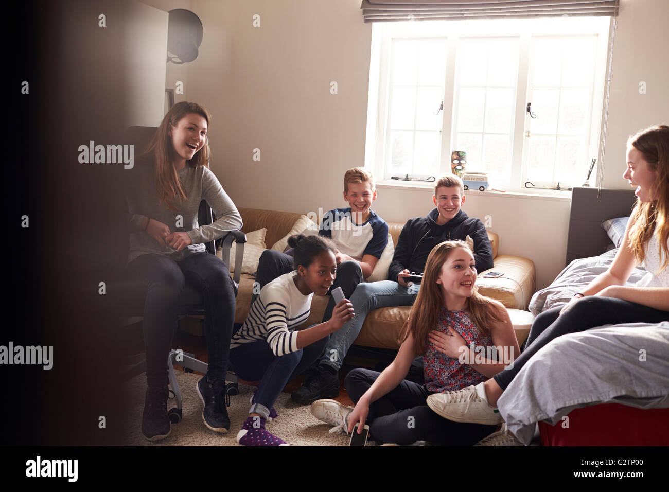 Group Of Teenagers Hanging Out In Bedroom Together Stock Photo