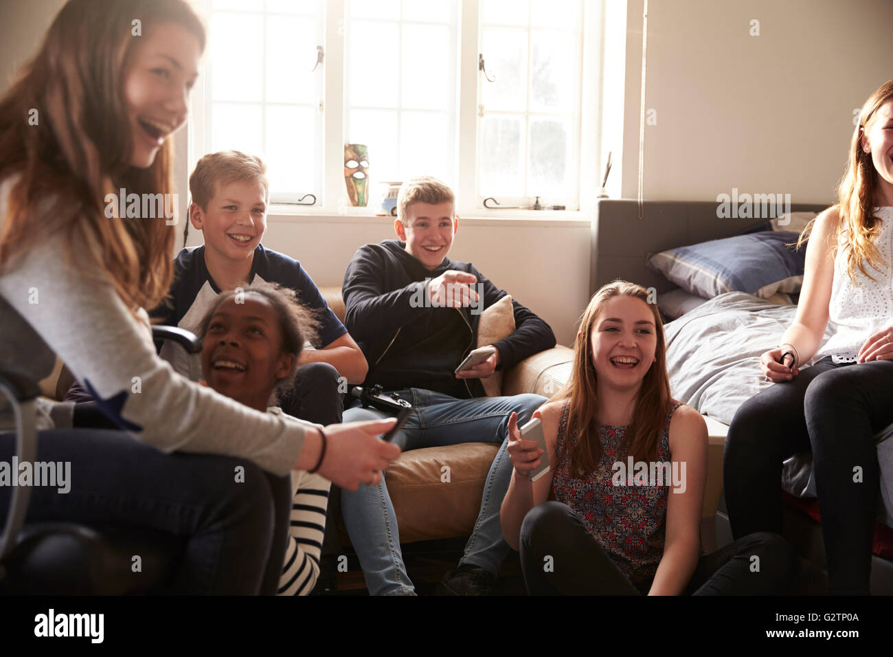 Group Of Teenagers Playing Video Game In Bedroom Stock Photo