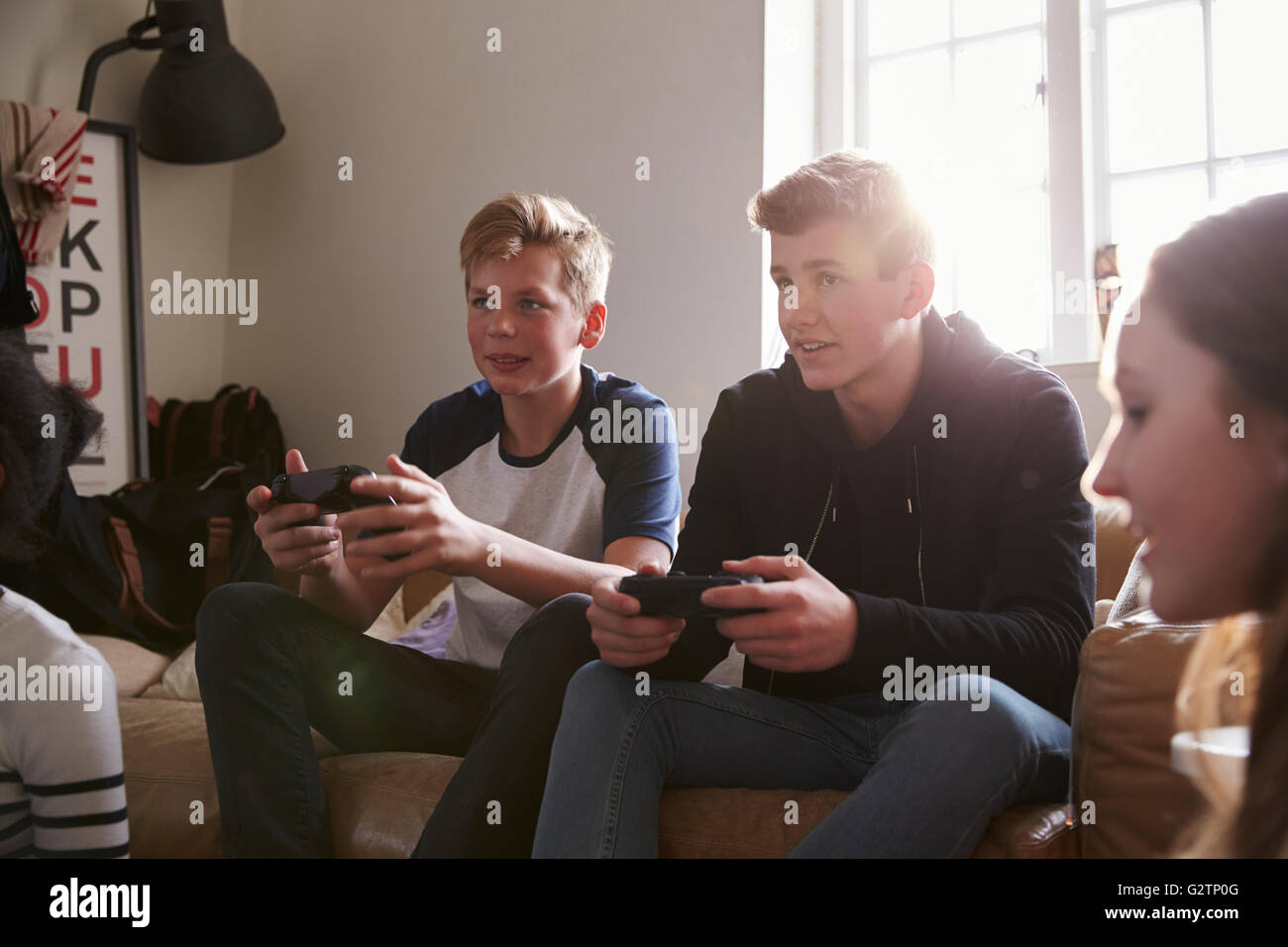 Two Teenage Boys Playing Video Game In Bedroom Stock Photo