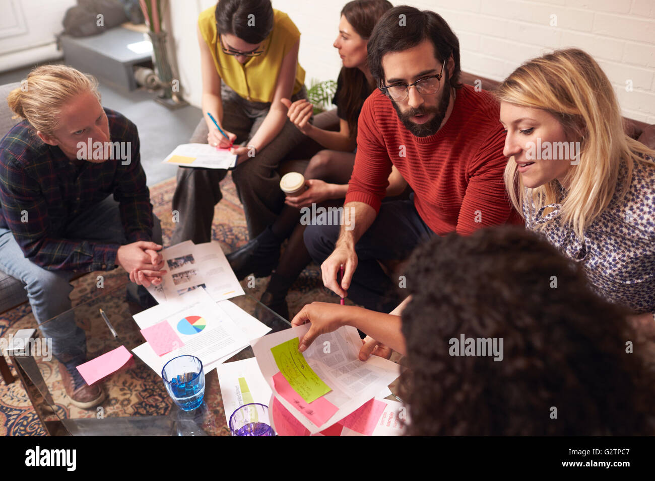 Designers Sitting On Sofa Having Creative Meeting In Office Stock Photo