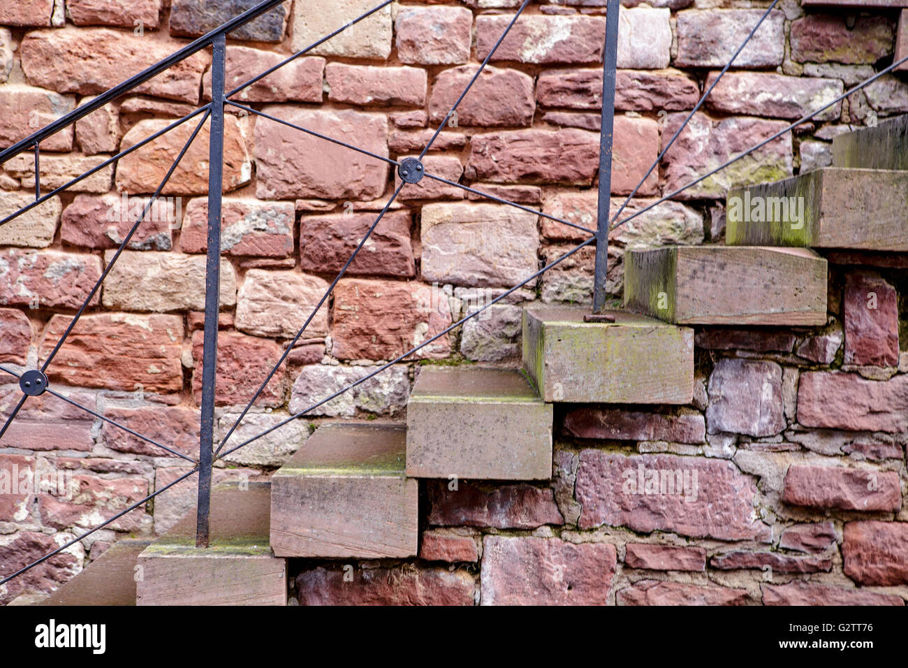Old Stone Stairway along sandstone wall with metal fence Stock Photo