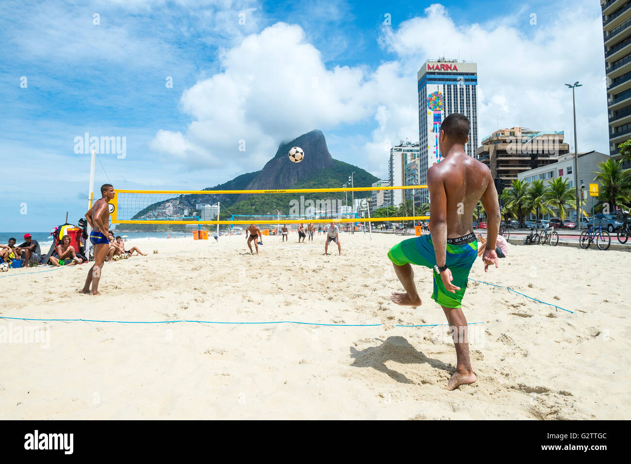 RIO DE JANEIRO - MARCH 17, 2016: Young Brazilian men play a game of futevolei (footvolley), combining football and volleyball Stock Photo
