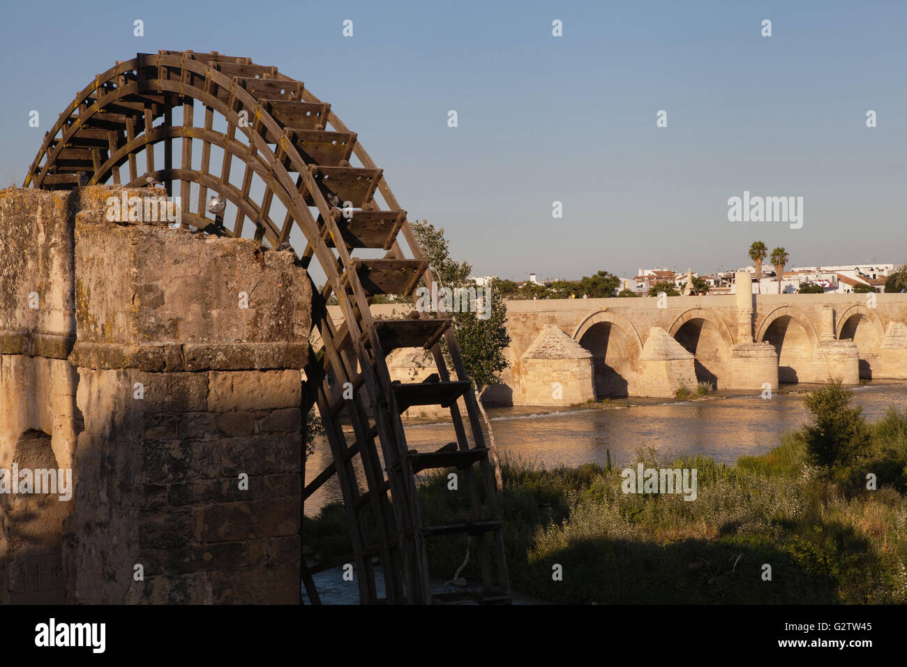 Spain, Andalucia, Cordoba, Noria on the Rio Guadalquivir with the Roman Bridge in the background. Stock Photo