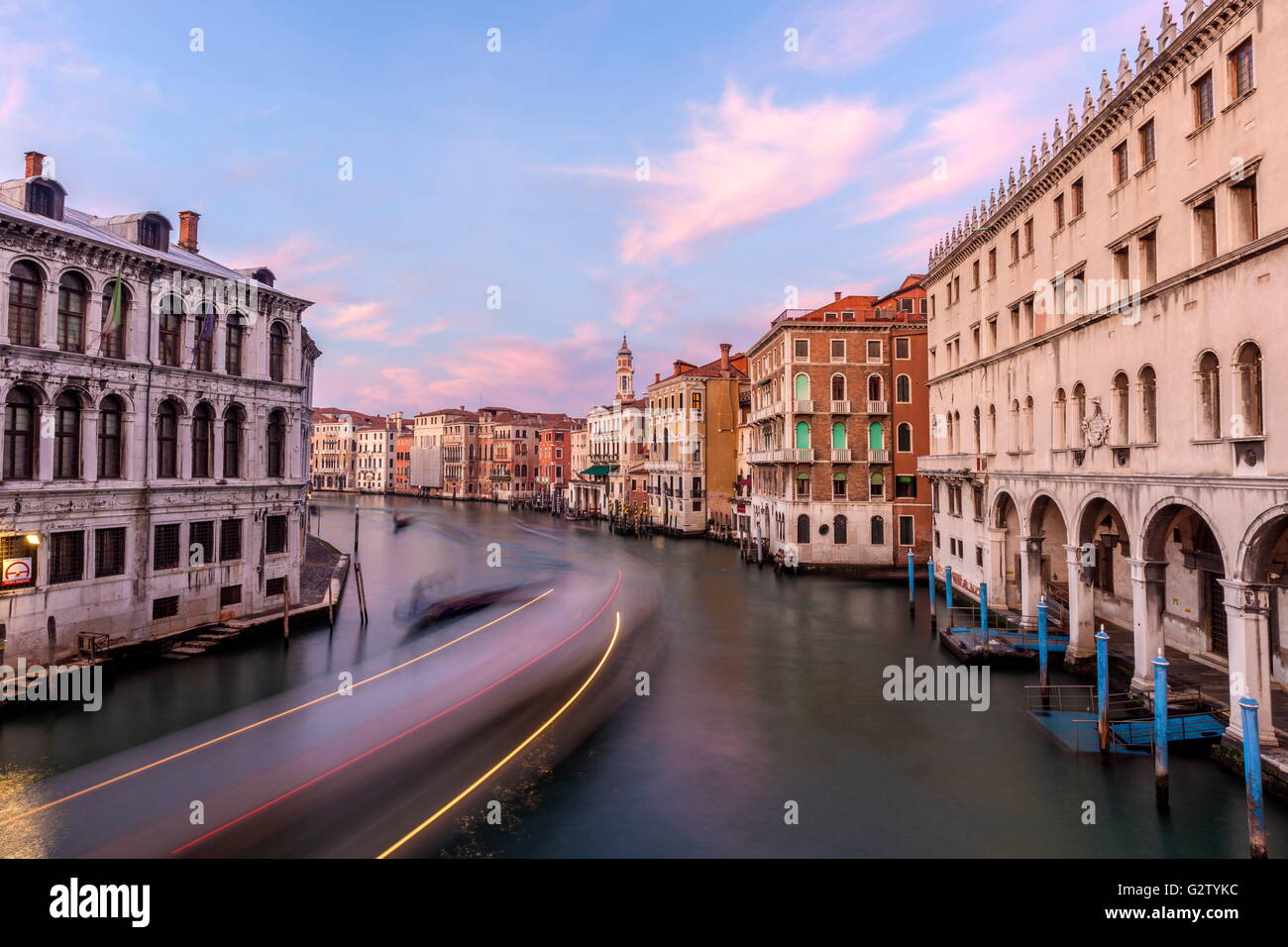 The typical gondolas at sunset in Canal Grande surrounded by the historic buildings and palaces in Venice Veneto Italy Europe Stock Photo