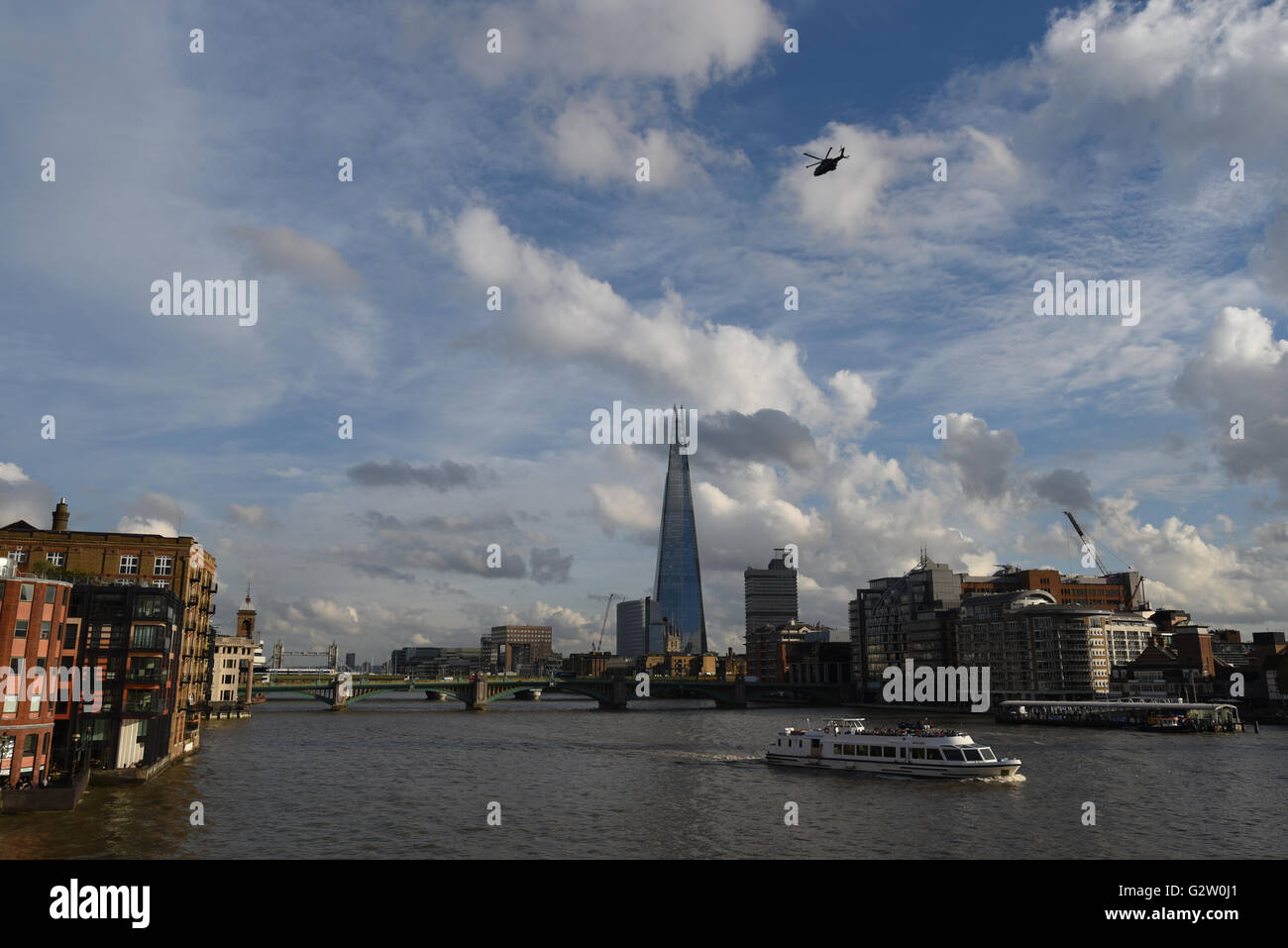 A scenic view of The Shard across London's River Thames, with a boat and helicopter. Stock Photo