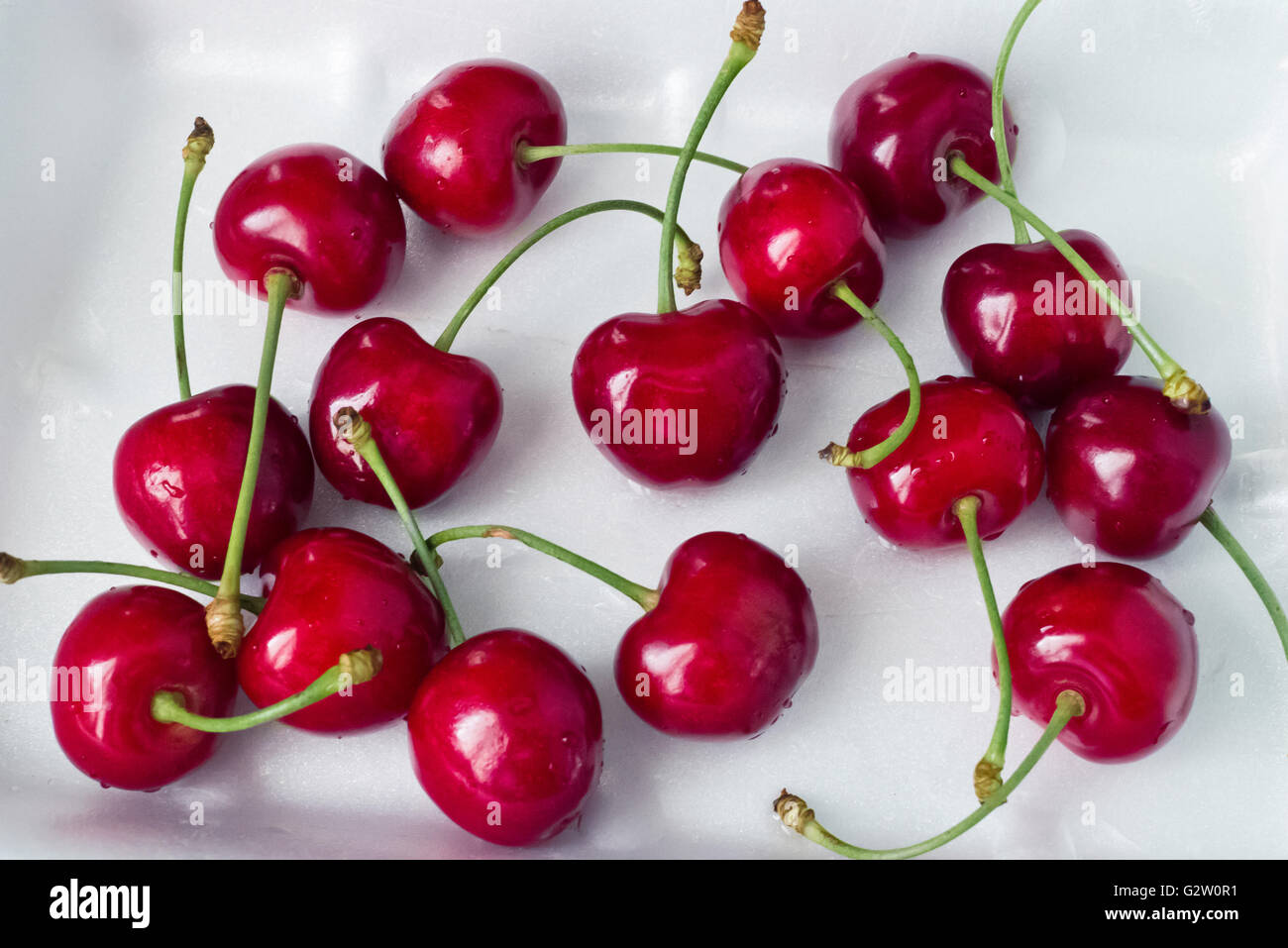 cherries scattered on white background. Stock Photo