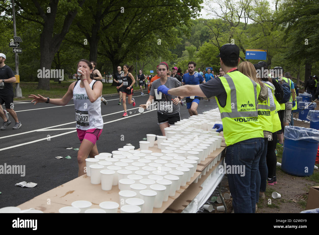 Over 28000 runners participated in the 2016 Brooklyn Half Marathon. The half way point was reached while running through Prospect Park. Volunteers at the water station around the halfway point of the race. Stock Photo