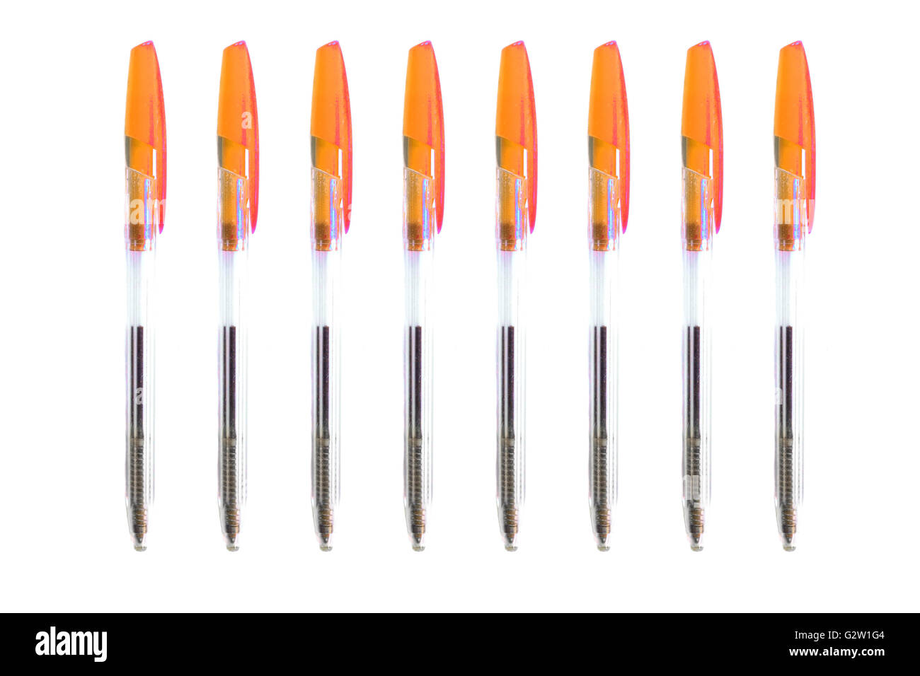 Orange biro pens photographed against a white background. Stock Photo