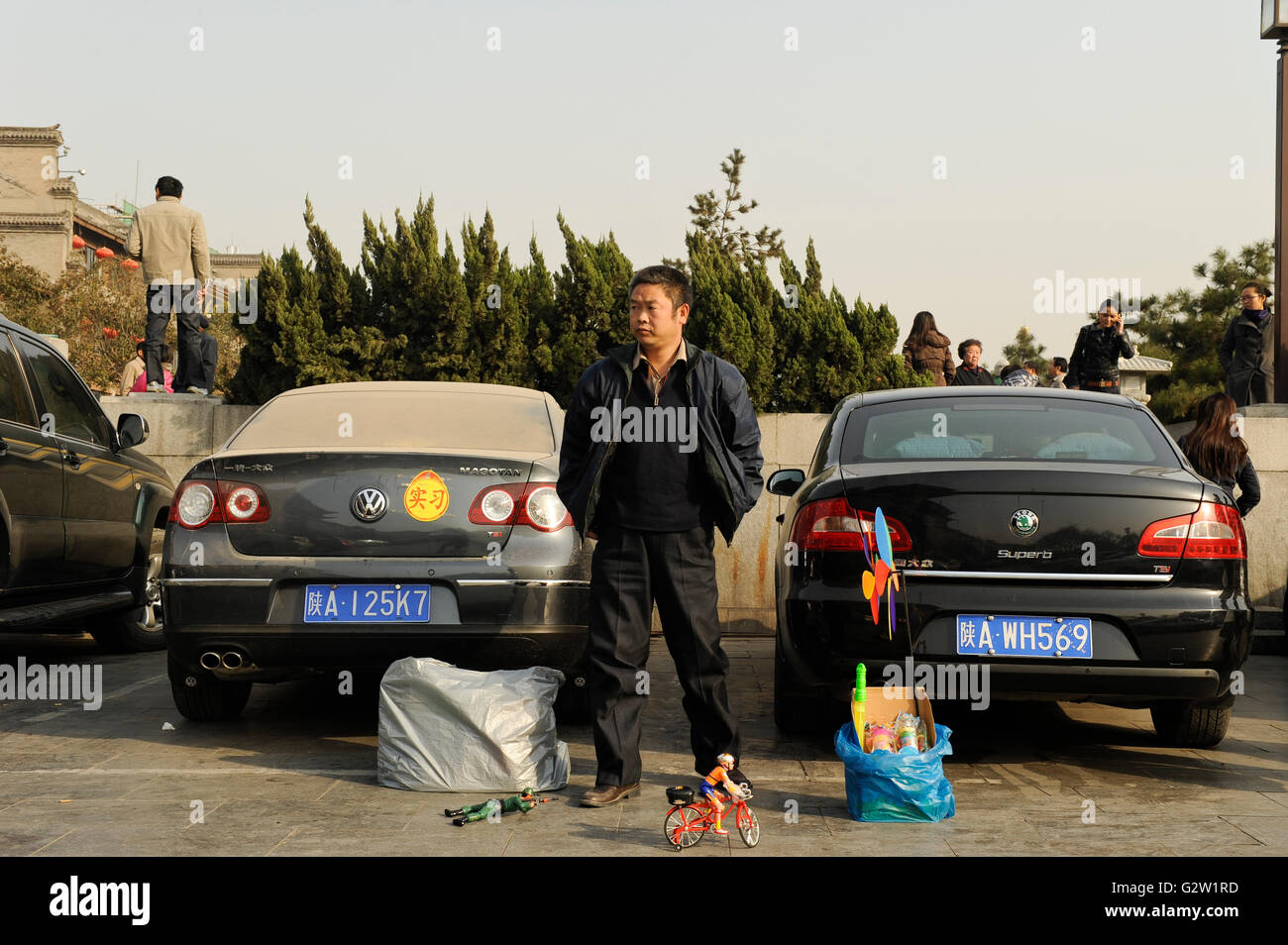 CHINA, Province Shaanxi, city Xian, parking VW Volkswagen and Skoda car, street vendor selling plastic toys Stock Photo