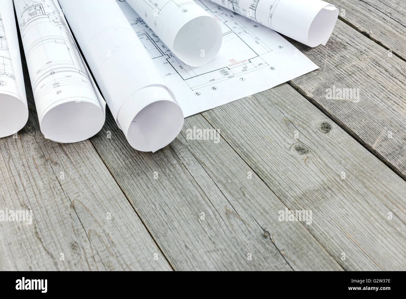 rolls of blueprints with architectural drawings on wooden desk Stock ...