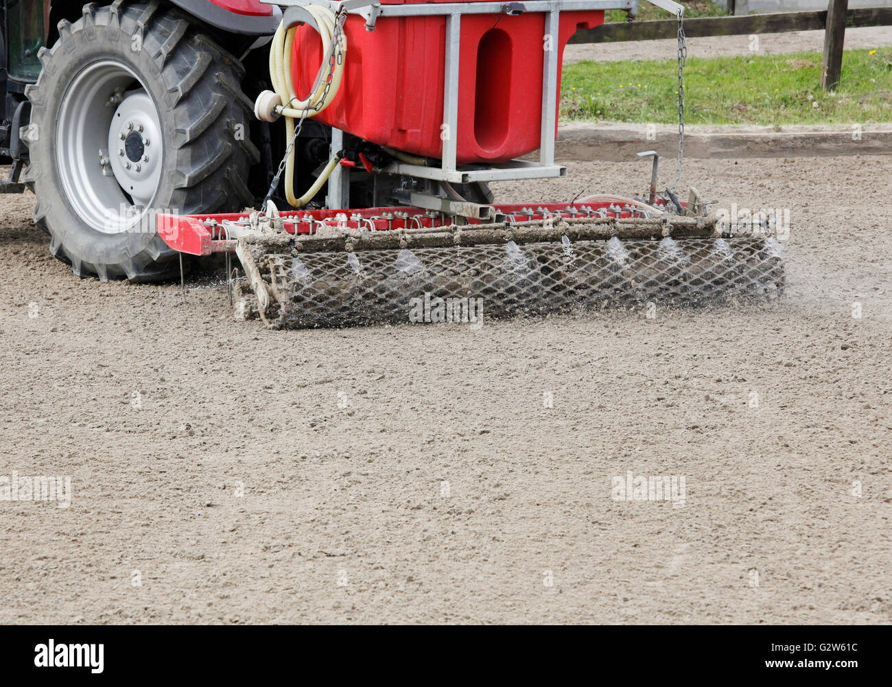 a modern riding arena planner with irrigation behind a tractor Stock Photo
