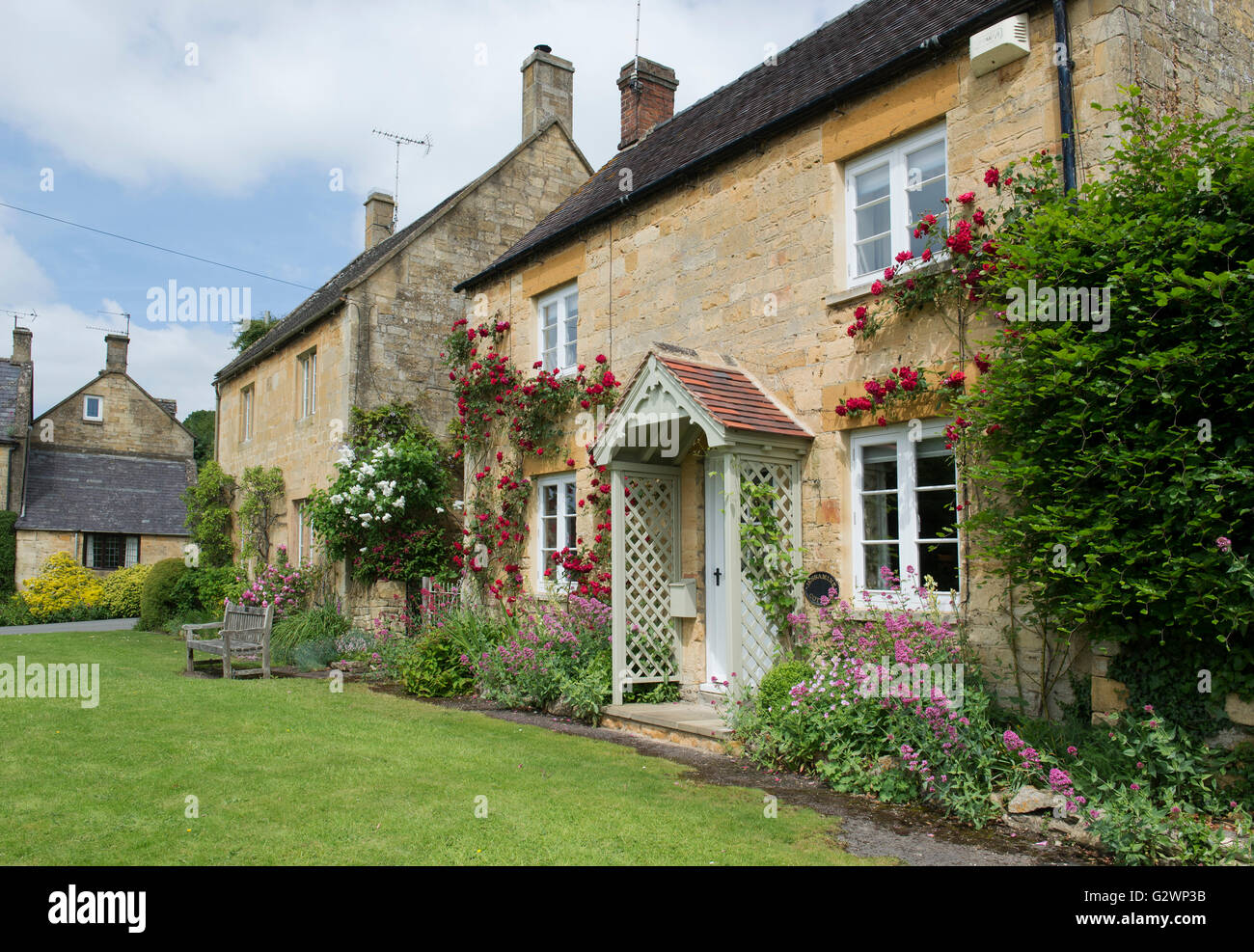 Cotswold stone cottages with red roses. Stanton, Cotswolds, Gloucestershire, England Stock Photo