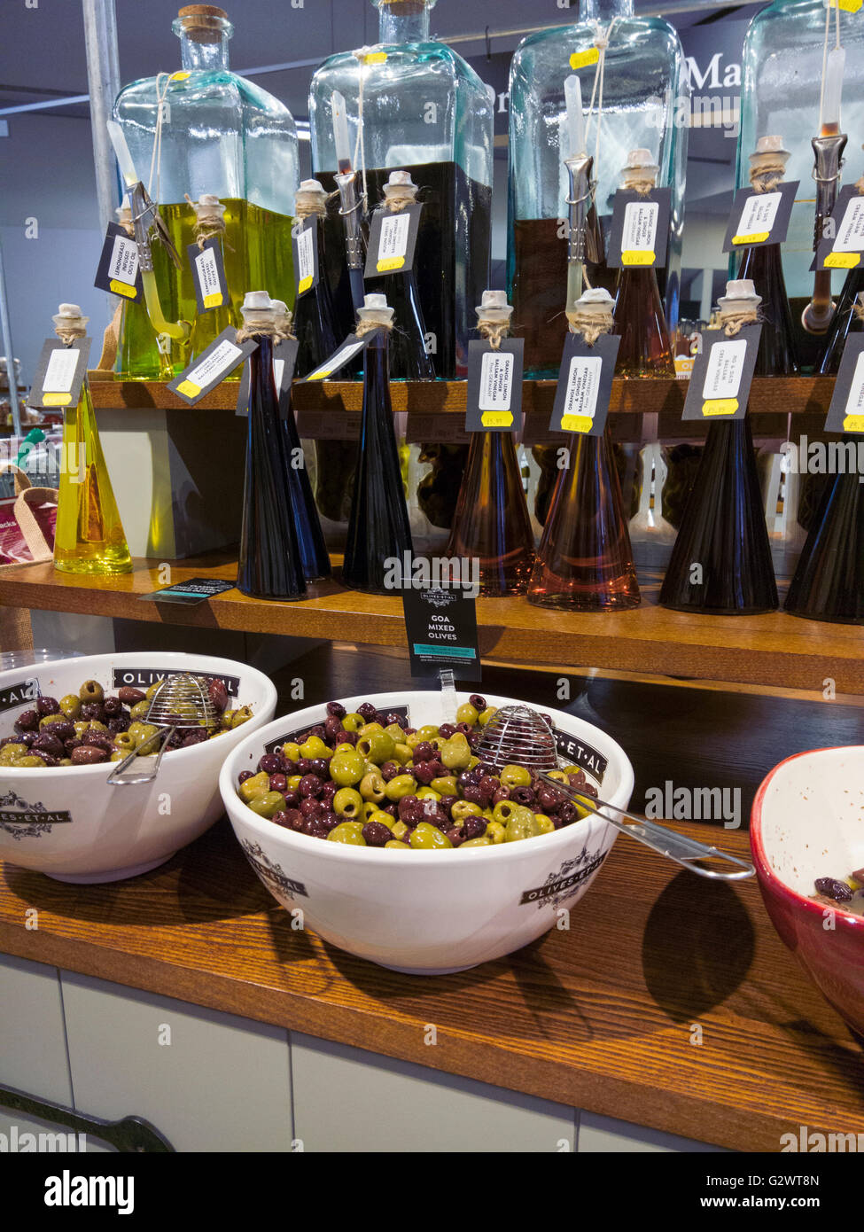 Flavoured Balsamic Vinegar and fresh olives on sale in a shop. Stock Photo