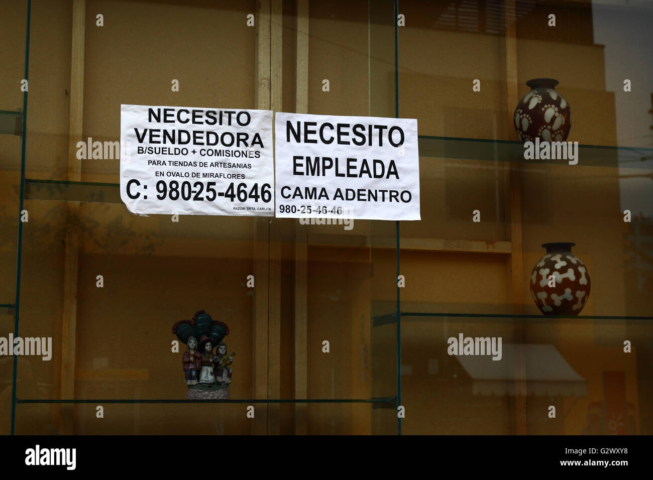 Notice advertising work for sales assistant and domestic help in Spanish on shop window, Miraflores, Lima, Peru Stock Photo