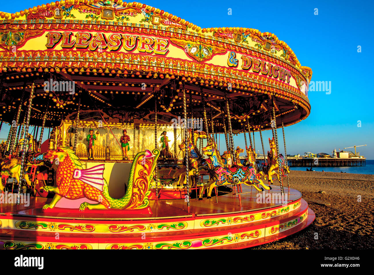 A carousel on Brighton beach with pier on background, East Sussex, England Stock Photo