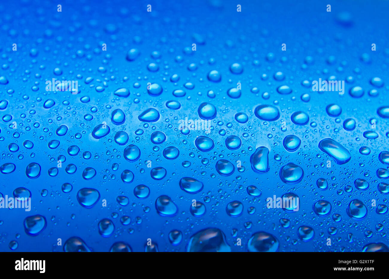 Water drops on round blue background, soft focus, close up Stock Photo