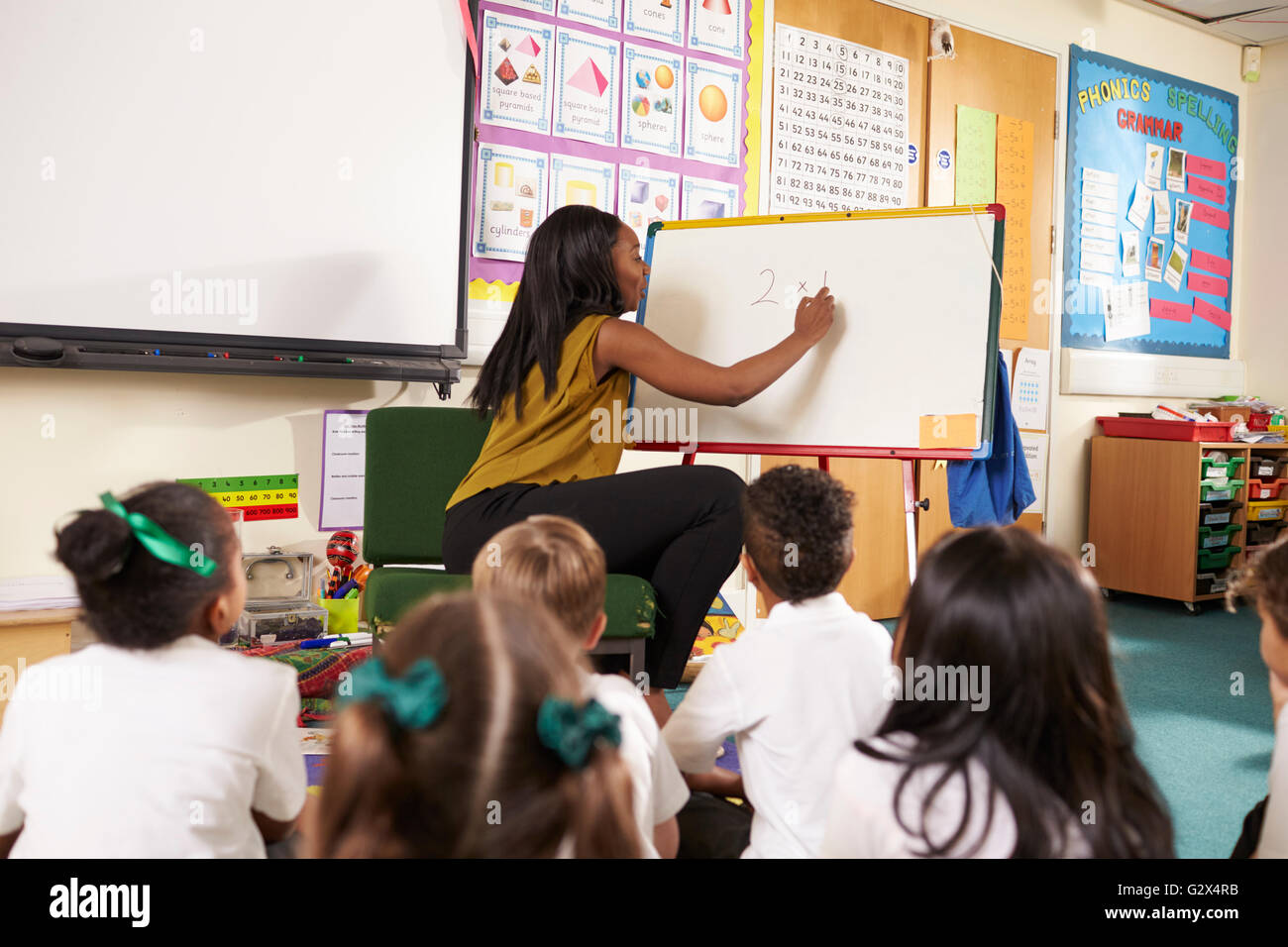 Teacher With Whiteboard In Elementary School Maths Class Stock Photo