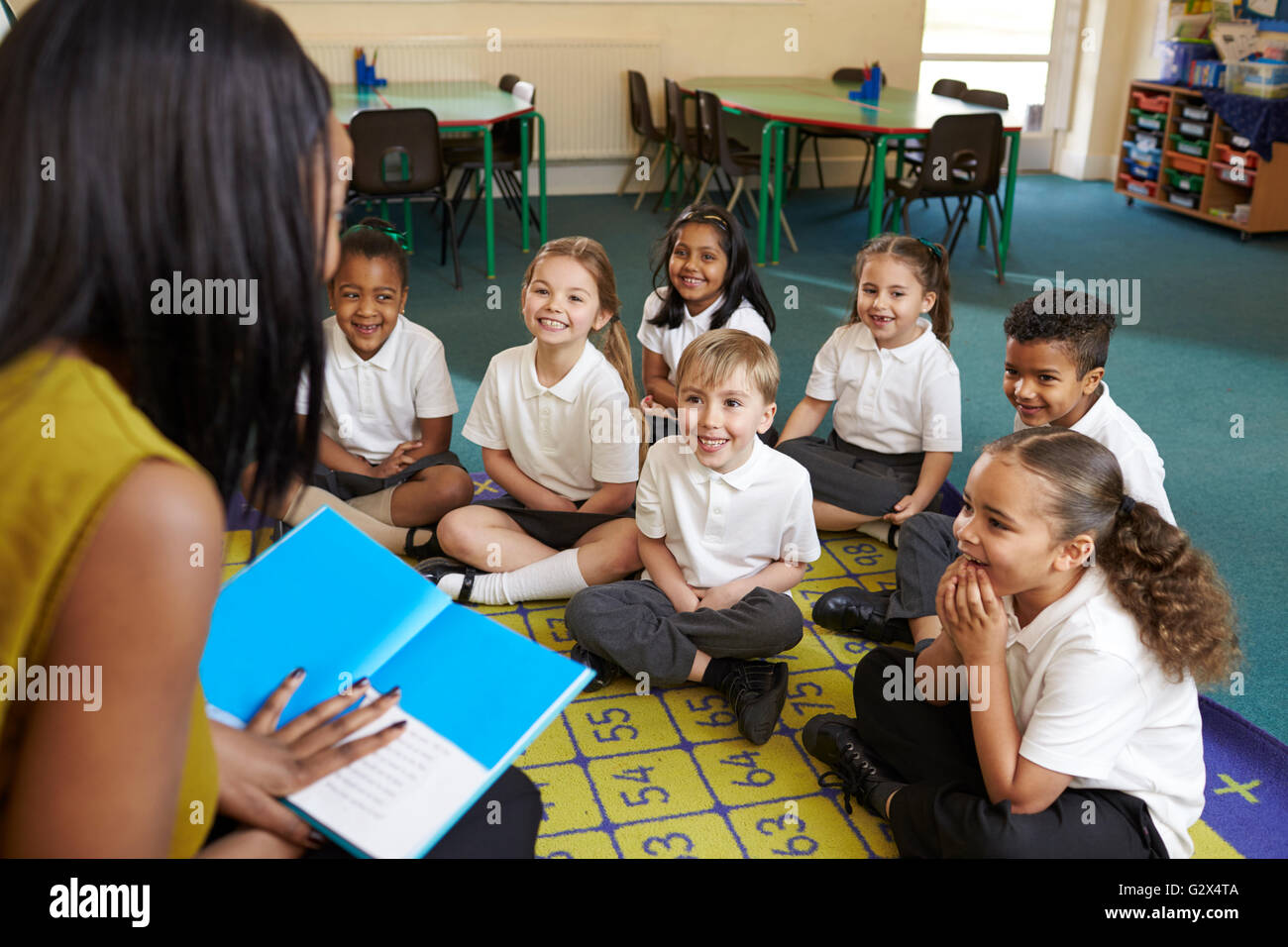 Teacher Reading To Elementary School Pupils In Classroom Stock Photo ...