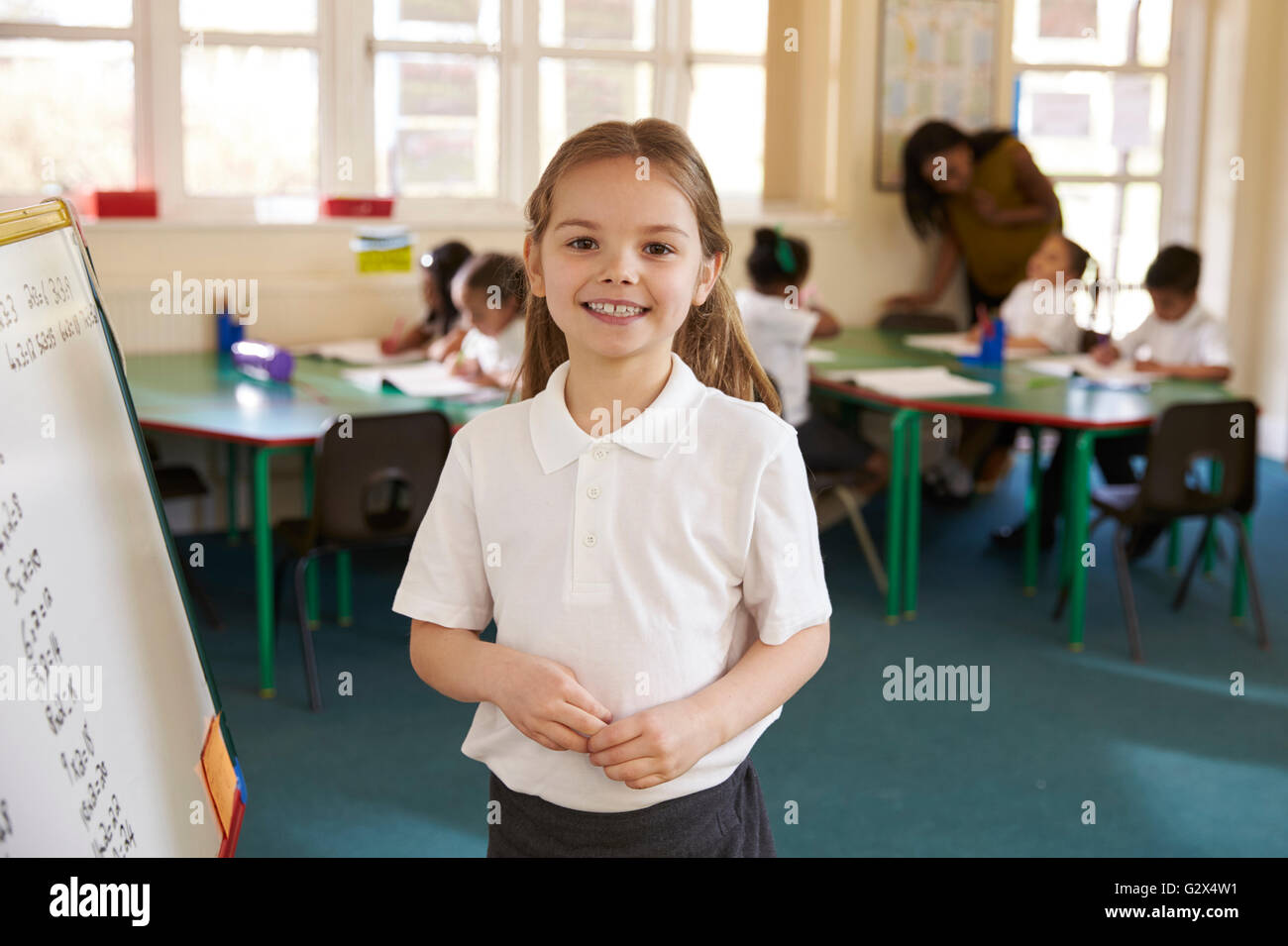 Portrait Of Elementary School Pupil With Whiteboard In Class Stock Photo