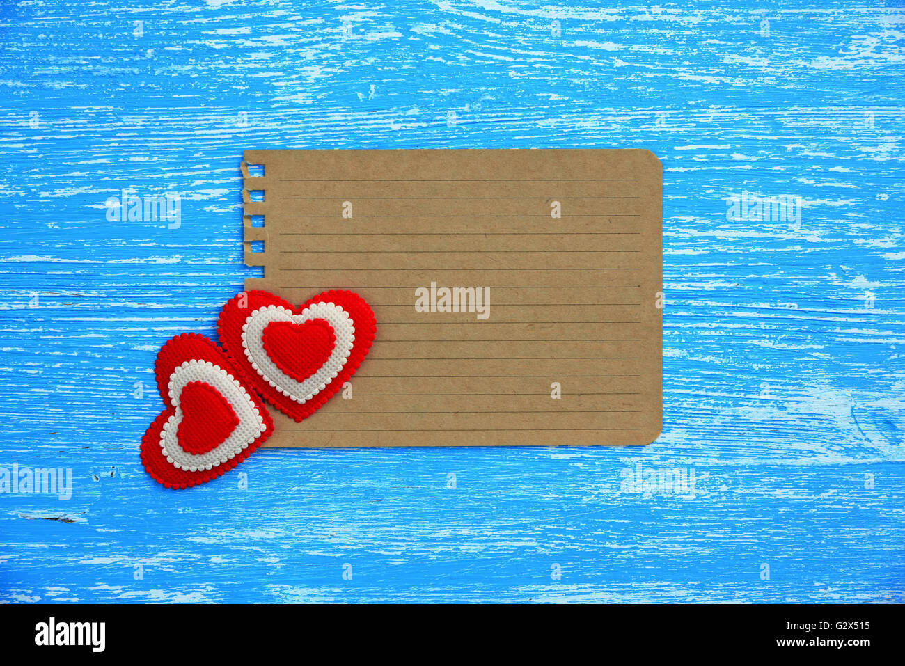Blank sheet of paper and hearts on a blue wooden background Stock Photo