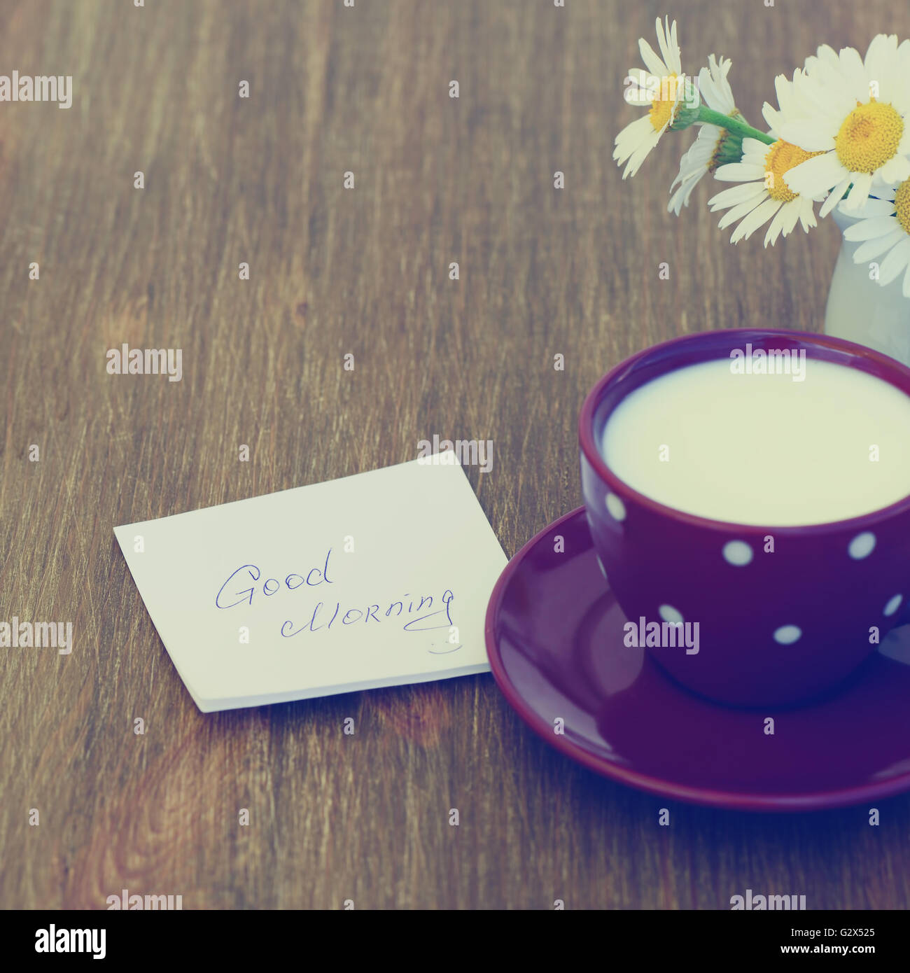 Daisy flowers and cup of milk with good morning note on rustic ...