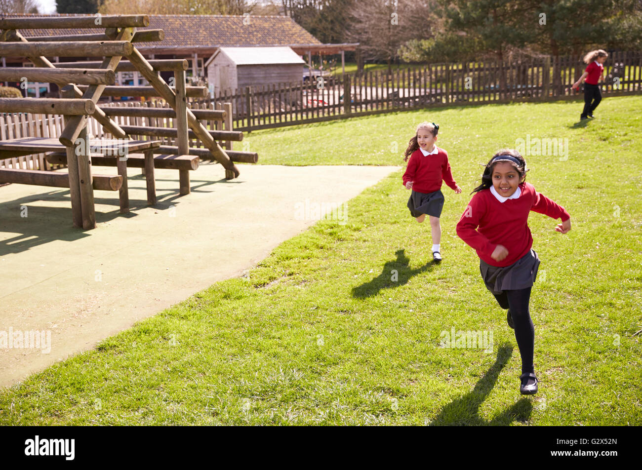 Female Elementary School Pupils Playing Tag At Breaktime Stock Photo