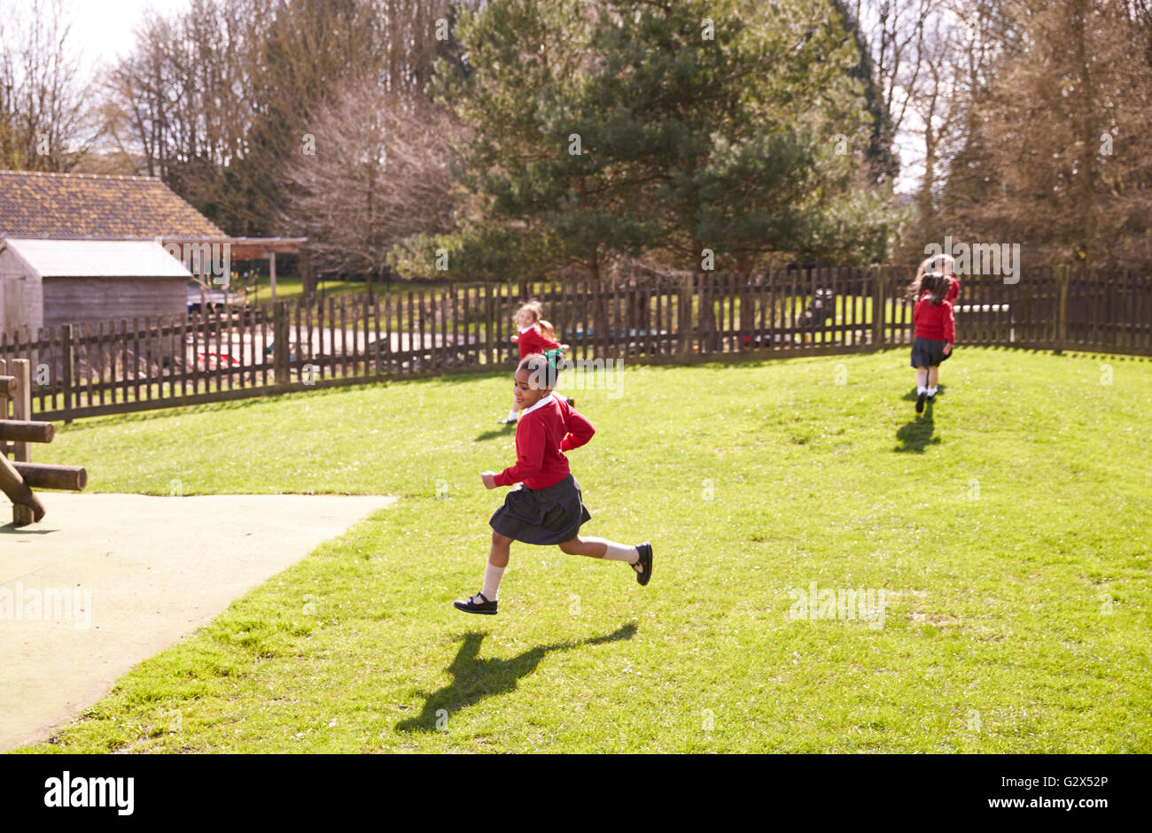 Female Elementary School Pupils Playing Tag At Breaktime Stock Photo