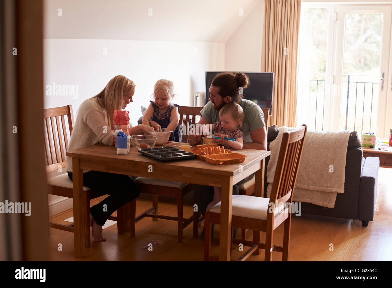 Family At Home Baking Cakes Together Stock Photo