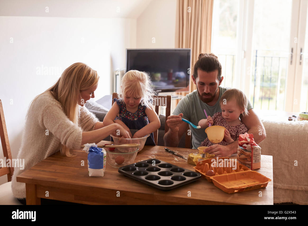 Family At Home Baking Cakes Together Stock Photo