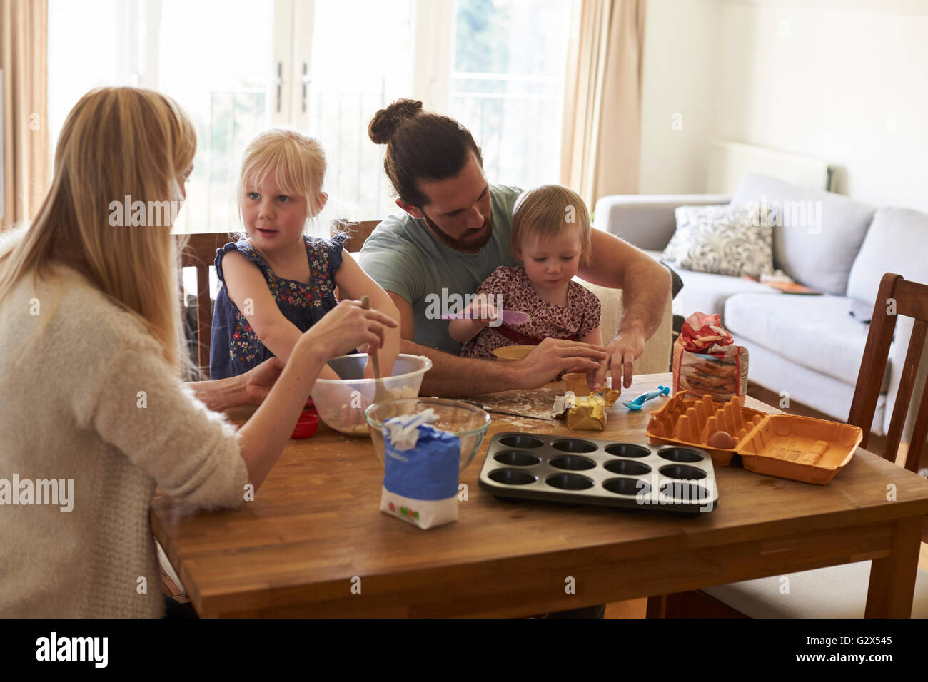 Family At Home Baking Cakes Together Stock Photo