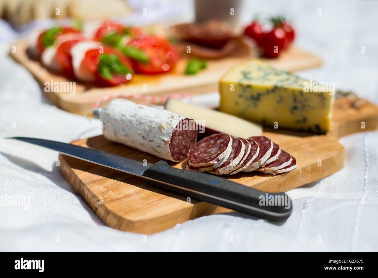 Close up of cut salami in a picnic of tomato and mozzarella salad