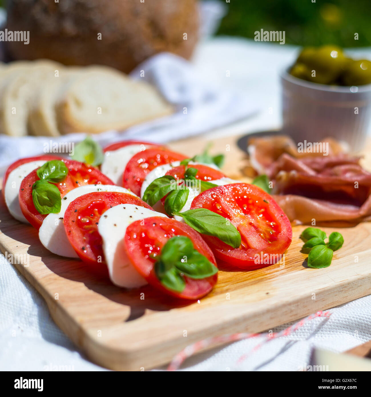 A picnic of tomato and mozzarella salad, parma ham, strawberries
