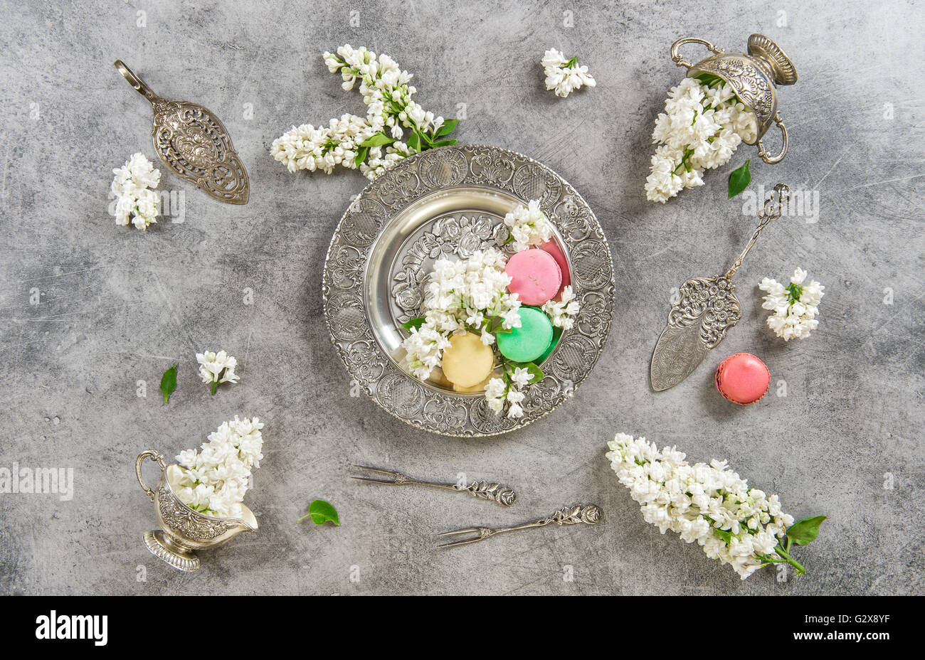 Macaroons. Creative food background. Vintage style flat lay with white lilac flowers Stock Photo