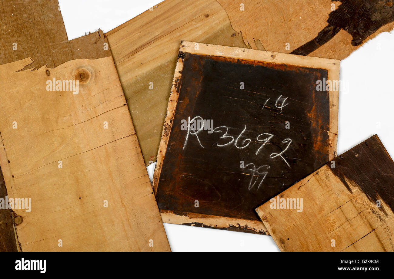 Cracked Layers On Old Plywood With Dark Paint and Numbers Written In Chalk White Background Stock Photo
