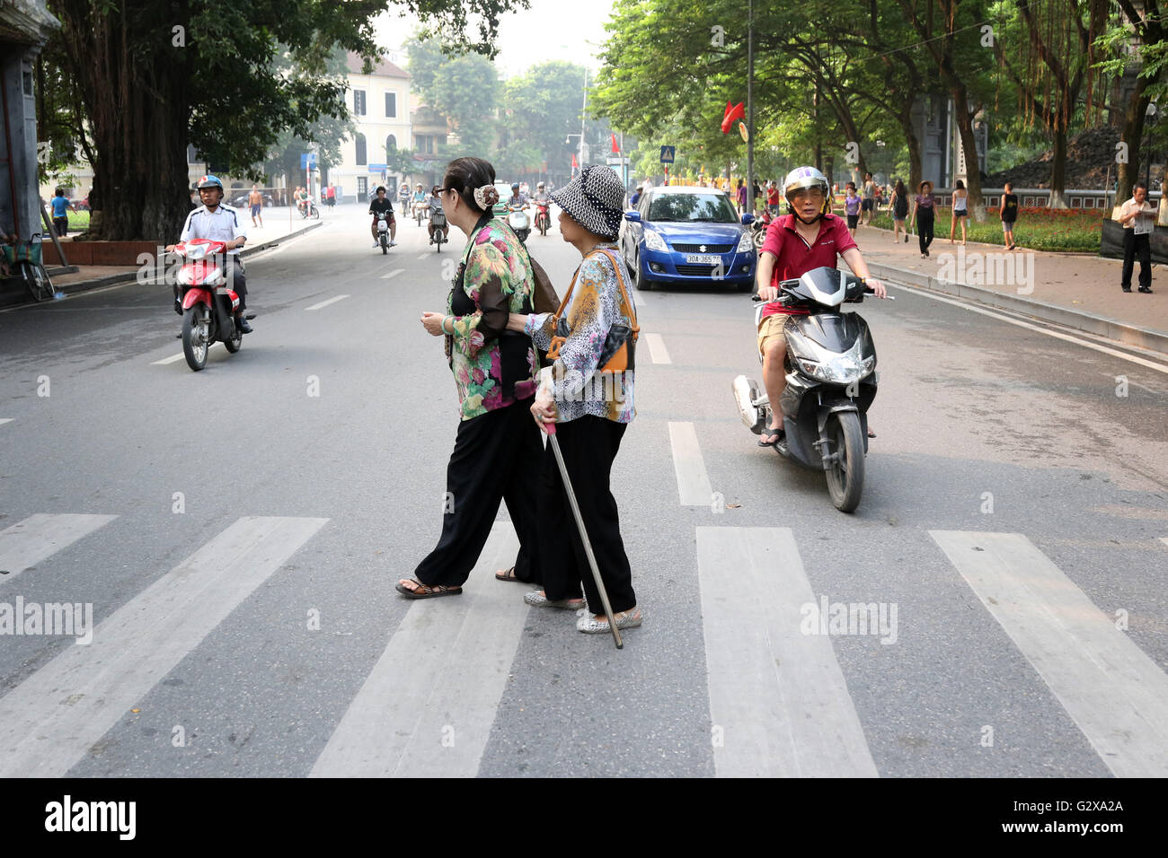 elderly ladies cross road Hanoi crossing Stock Photo