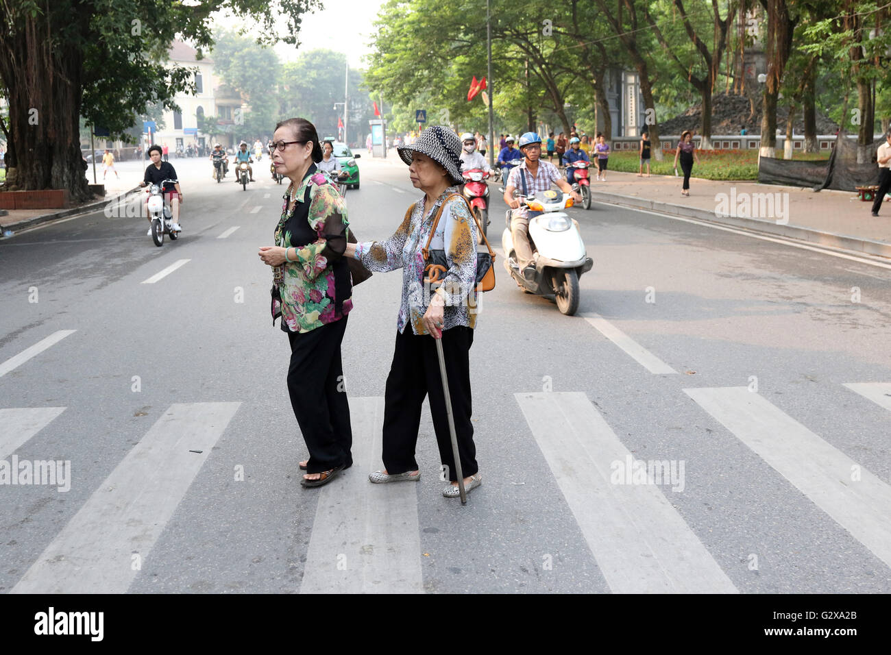 elderly ladies cross road Hanoi crossing Stock Photo