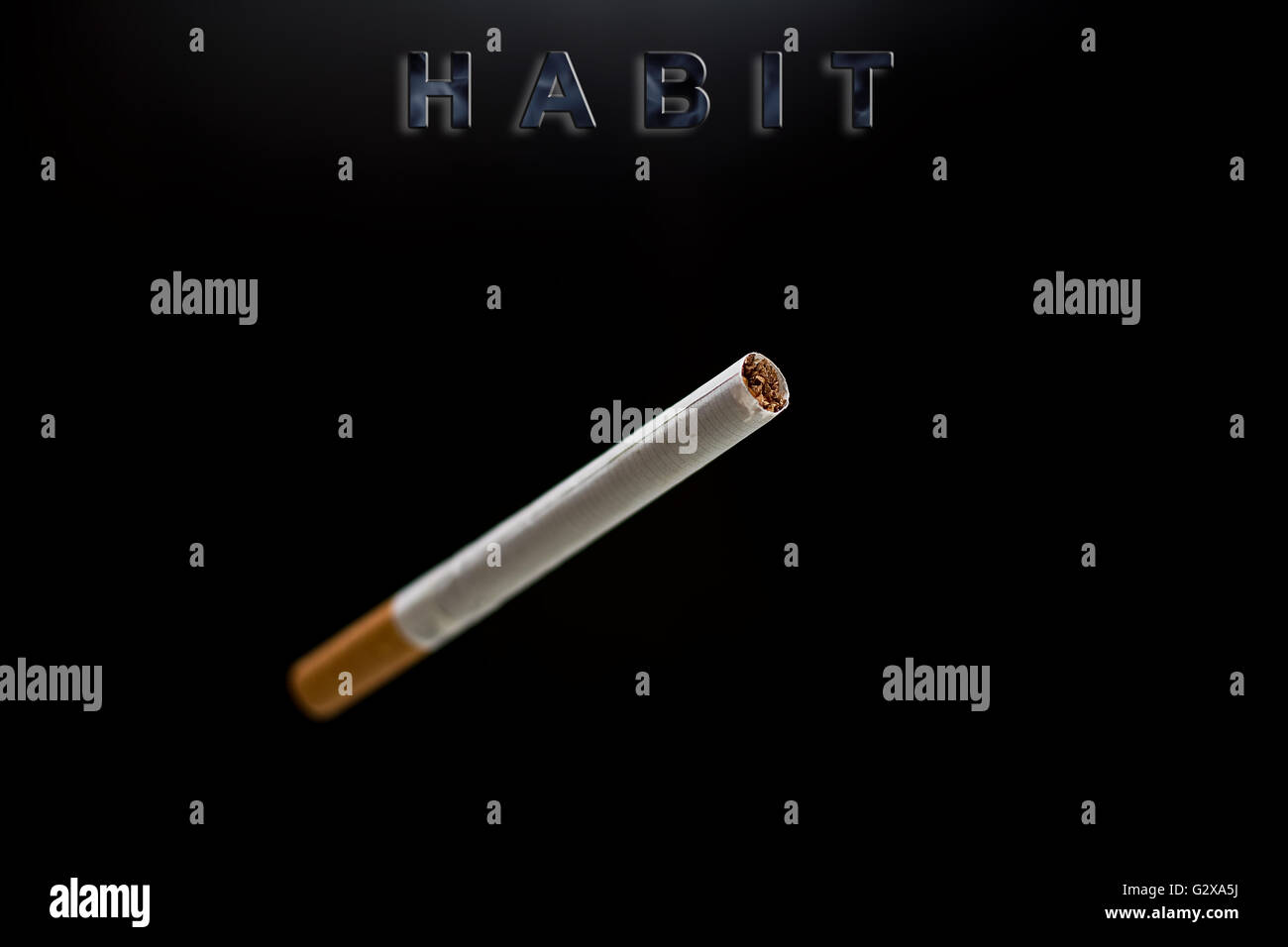 cigarette, text habit on black background Stock Photo