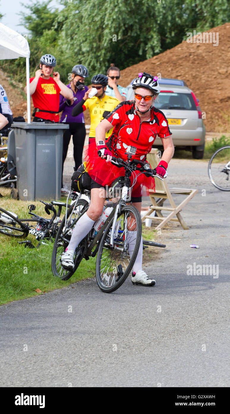 Older woman on the Dunwich Dynamo overnight bicycle ride wearing a red tutu. Stock Photo